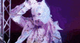 a woman is wearing a cat mask and holding her hair