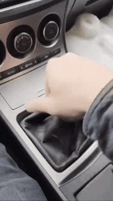 a close up of a person 's hand on the shifter of a car