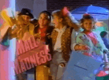 a group of people standing in front of a sign that reads mall madness