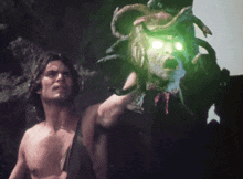 a man is holding a statue with a green light coming out of it