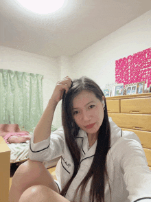 a woman wearing a white pajama top with the letters j and p on the front