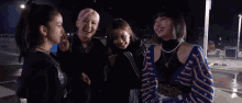 a group of young women are posing for a picture together at night .