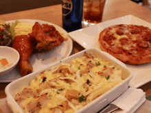 a blue can of pepsi sits on a table next to a plate of food