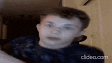 a close up of a young man 's face with the website clideo.com in the corner