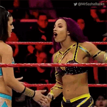 a woman is shaking hands with another woman in a ring .