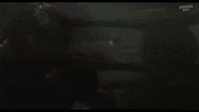 a man is being punched in the face in a dark room .