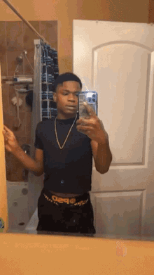 a young man taking a selfie in a bathroom