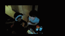 a person holding another person in a dark room with a bag of cheetos in the foreground