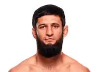 a man without a shirt has a beard and is looking at the camera