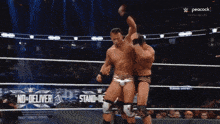 two wrestlers in a wrestling ring with a peacock ad in the corner