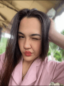 a woman in a pink shirt is making a silly face