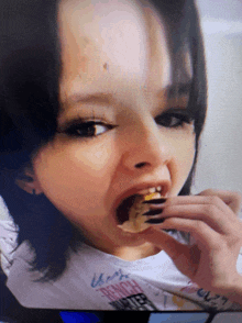 a little girl wearing a shirt that says french fries is eating something
