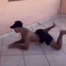 a shirtless man is crawling on the floor with his legs crossed .