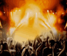 a crowd of people raising their arms in the air at a concert