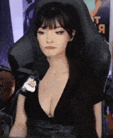 a woman with long hair is sitting in a chair with a microphone on her arm .