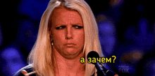 a woman with blonde hair is holding a microphone and making a funny face