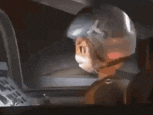 a cartoon character wearing a helmet is sitting in front of a computer .