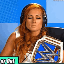 a woman is wearing headphones and holding a championship belt .