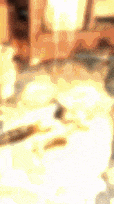 a blurred image of a person standing in a room with a yellow background