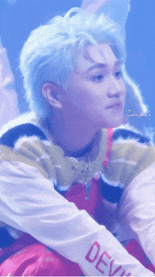 a boy with blue hair is wearing a shirt that says devil on the sleeve