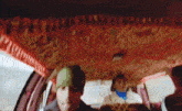 a blurry picture of people sitting in a car with a red ceiling