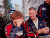 a group of young men are sitting at a table drinking beer .