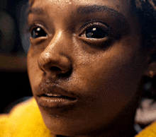 a close up of a woman 's face with a yellow background