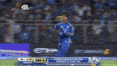 a blurred image of a cricket game with the score 189-5 on the screen
