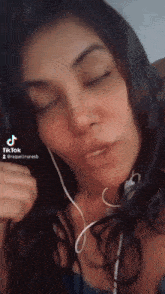 a woman wearing headphones and a tiktok sticker