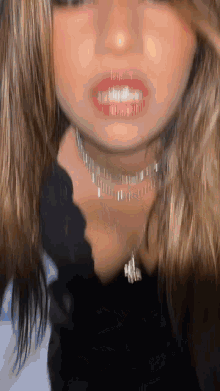 a close up of a woman 's face wearing a choker necklace and red lipstick .