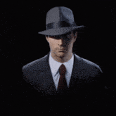 a man in a suit and hat is looking at the camera
