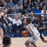 a basketball game is being played in front of a crowd and one player has the number 2 on his jersey