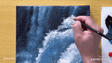 a hand is holding a brush in front of a painting that says made in animatica