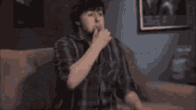 a man with a beard is eating a candy bar while sitting at a table .