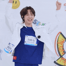 a boy wearing a blue shirt that says thi-o on it