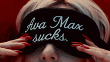 a woman with long red nails is wearing a black eye mask that says ava max sucks