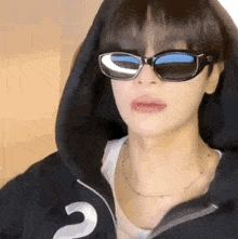 a close up of a person wearing sunglasses and a hooded jacket .
