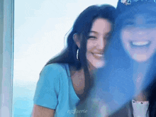 two women are standing next to each other and smiling .
