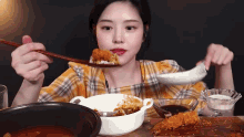a woman is eating food with a spoon and a spoon in her mouth .