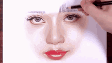 a person is drawing a woman 's face with a pencil on a piece of paper .