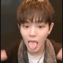 a young man is sticking his tongue out in a funny face .