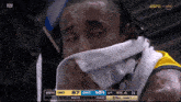 a man with a towel around his neck is crying while watching a basketball game on espn