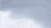 a blurred image of a snowy mountain with a blue sky in the background