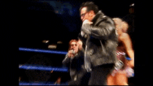 a man in a leather jacket and sunglasses is holding a gun .