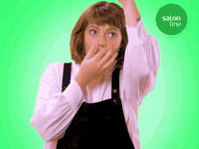 a woman covering her mouth with her hand in front of a green circle with salon line written on it