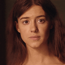 a close up of a woman 's face with a serious look on her face
