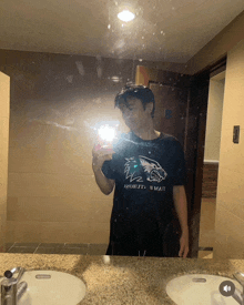 a man is taking a picture of himself in a bathroom mirror with a shirt that says " i 'm matt " on it
