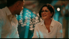 a man and a woman are looking at each other and the woman is wearing glasses