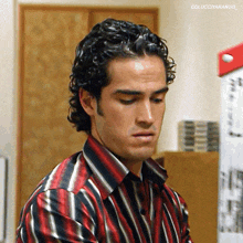 a man with curly hair is wearing a red and black striped shirt with the caption colucciyarango_