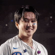 a close up of a man wearing a white shirt and earbuds .